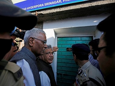 Sitaram Yechury and D Raja waiting out side the door of Syed Ali Shah Gellani in Srinagar on Sunday. PTI