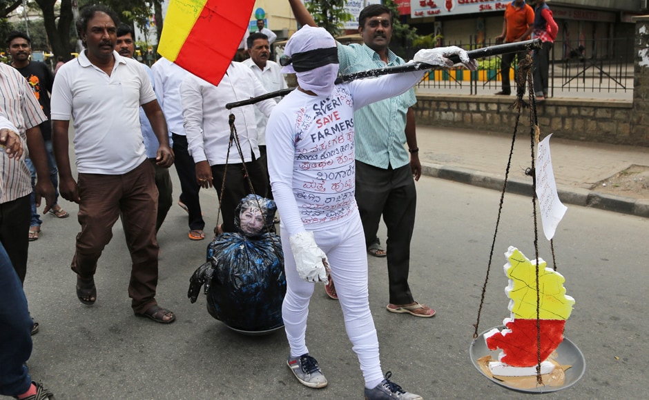 A supporter of a pro-Kannada organization carries a scale with an effigy of Tamil Nadu CM Jayalalithaa on one side and a map of Karnataka state on another, during a protest against a recent Supreme Court order on the Cauvery issue. Normal life was severely affected across Karnataka during the dawn-to-dusk strike. AP A supporter of a pro-Kannada organization carries a scale with an effigy of Tamil Nadu CM Jayalalithaa on one side and a map of Karnataka state on another, during a protest against a recent Supreme Court order on the Cauvery issue. Normal life was severely affected across Karnataka during the dawn-to-dusk strike. AP