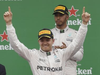 Nico Rosberg celebrates his win in Monza while Lewis Hamilton looks on. AP