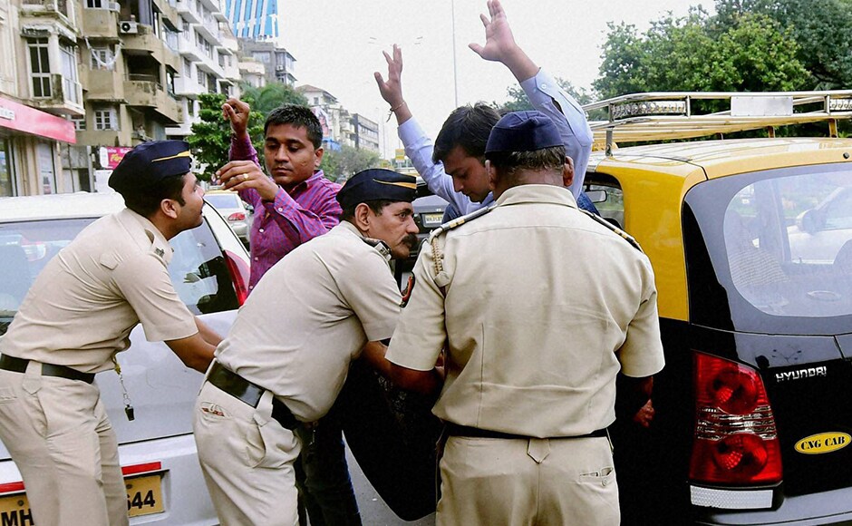 Mumbai police frisk passengers at a checkpost. PTI Mumbai police frisk passengers at a checkpost. PTI