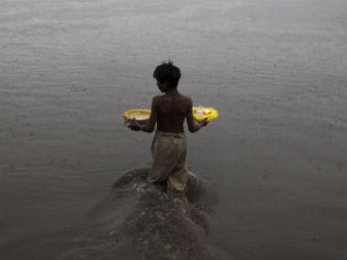 A boy enters river Ravi to release oil lamps and candles in water. Reuters