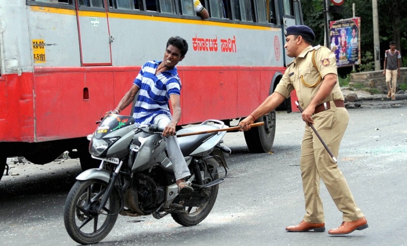 A policeman charges a miscreant riding a motorcycle during prohibitory order at Sunkadakatte in Bengaluru on Tuesday. PTI