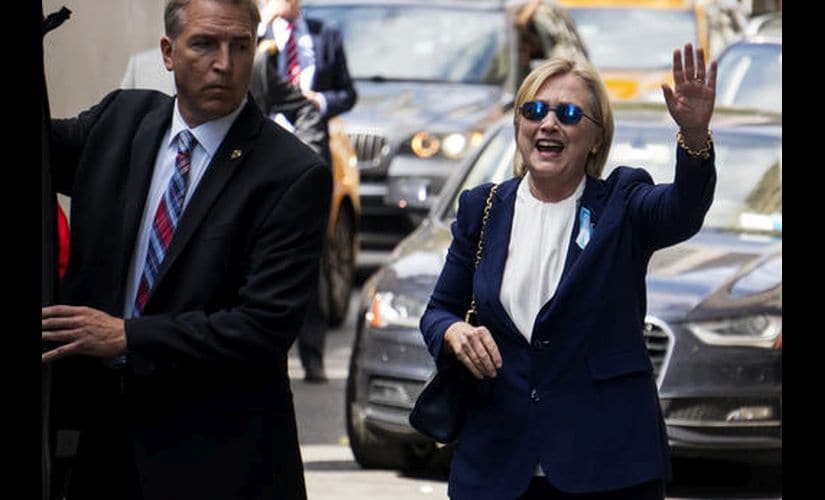 Democratic presidential candidate Hillary Clinton waves as she walks from her daughter's apartment building on Sunday. AP