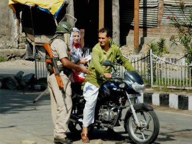 Security guard checks the curfew of a couple in Srinagar. PTI