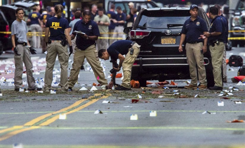FBI officials search the site of attack. AP