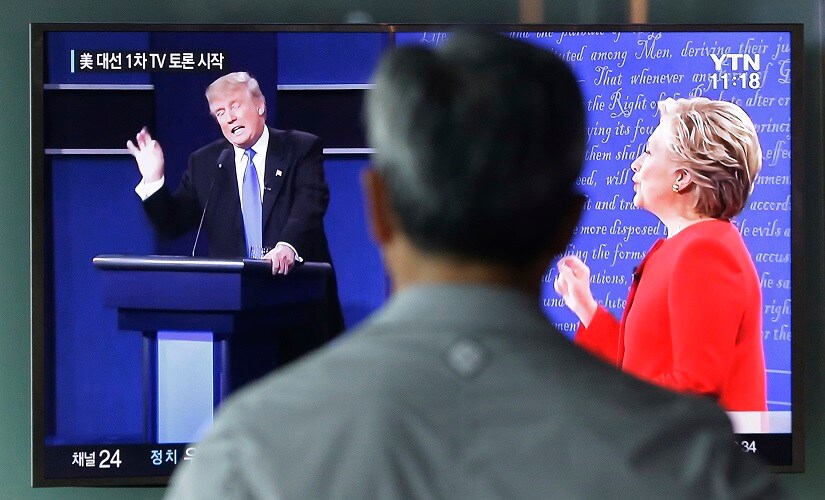 A man watches a TV screen showing the live broadcast of the US presidential debate between Democratic presidential nominee Hillary Clinton and Republican presidential nominee Donald Trump, at Seoul Railway Station in Seoul, South Korea. AP