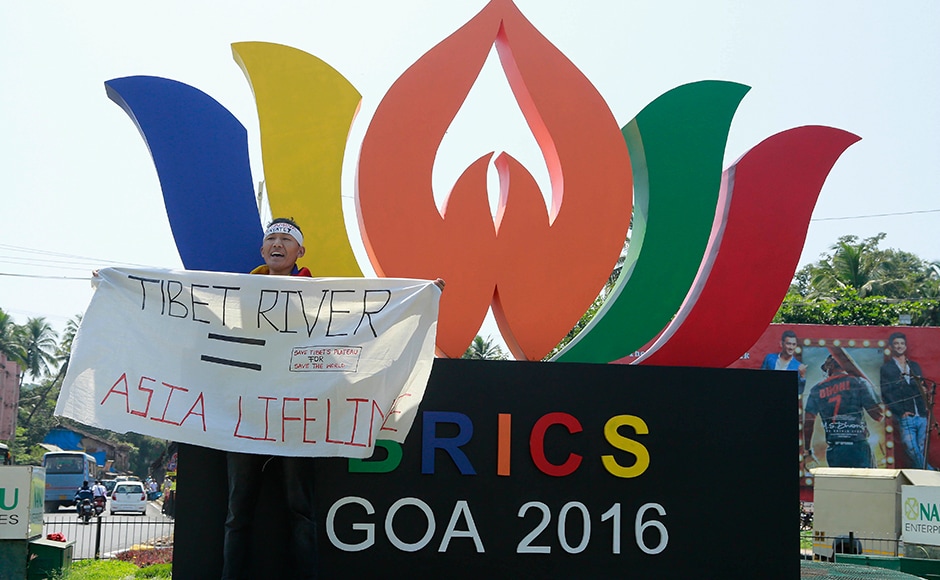 A Tibetan holds a banner and protests against the Chinese government, as Chinese President Xi Jinping arrives at the summit venue in Goa on Saturday. (Photo: AP) A Tibetan holds a banner and protests against the Chinese government, as Chinese President Xi Jinping arrives at the summit venue in Goa on Saturday. (Photo: AP)
