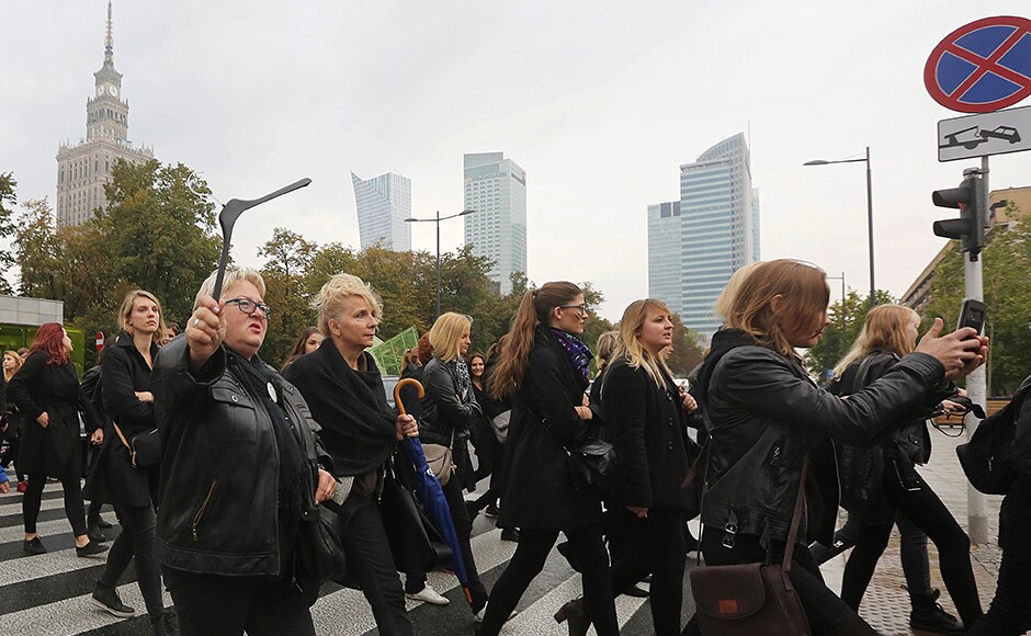 A large crowd gathered in the rain in central Warsaw and people were out on the streets in other cities. People held up signs, including A large crowd gathered in the rain in central Warsaw and people were out on the streets in other cities. People held up signs, including