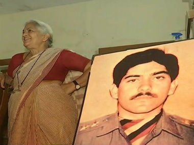Nirmala Devi Sharma stands alongside the picture of her martyred son Captain Devashish Sharma. News18