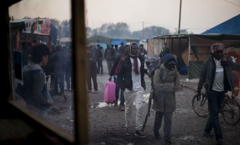 Migrants moving towards buses which will take them to shelters. AP
