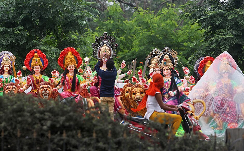 A woman rides past an artist giving finishing touches to an idol of Goddess Durga in Hyderabad, India. Navratri lasts for nine days, with three days each devoted to the worship of Durga, the goddess of valor, Lakshmi, the goddess of wealth, and Saraswati, the goddess of knowledge. AP A woman rides past an artist giving finishing touches to an idol of Goddess Durga in Hyderabad, India. Navratri lasts for nine days, with three days each devoted to the worship of Durga, the goddess of valor, Lakshmi, the goddess of wealth, and Saraswati, the goddess of knowledge. AP