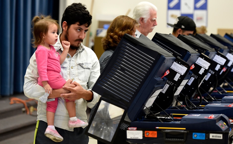A man holds a young girl as he casts his ballot in Las Vegas, Nevada. Reuters A man holds a young girl as he casts his ballot in Las Vegas, Nevada. Reuters