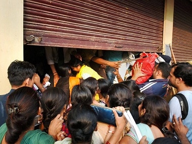 People crowd at outside of a bank in New Delhi on Saturday. PTI