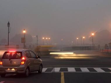 Vehicles ply on smog covered Rajpath in New Delhi on Saturday. PTI