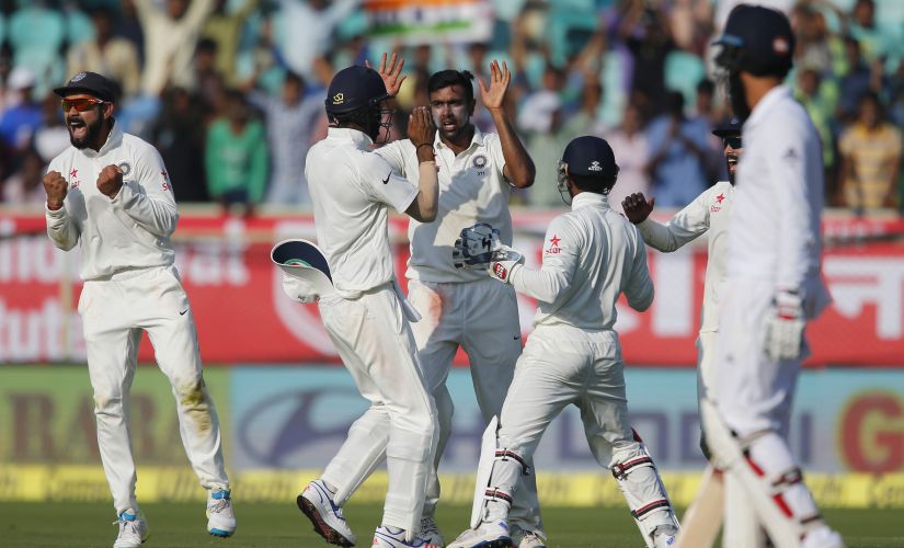 Ravichandran Ashwin celebrates with teammates the dismissal of Joe Root on the second day of Vizag Test. AP
