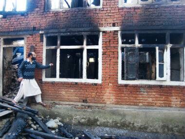 Dildar Ahmad Bhat stands next to a class room of Iqra Public School which was burnt. Sameer Yasir/Firstpost