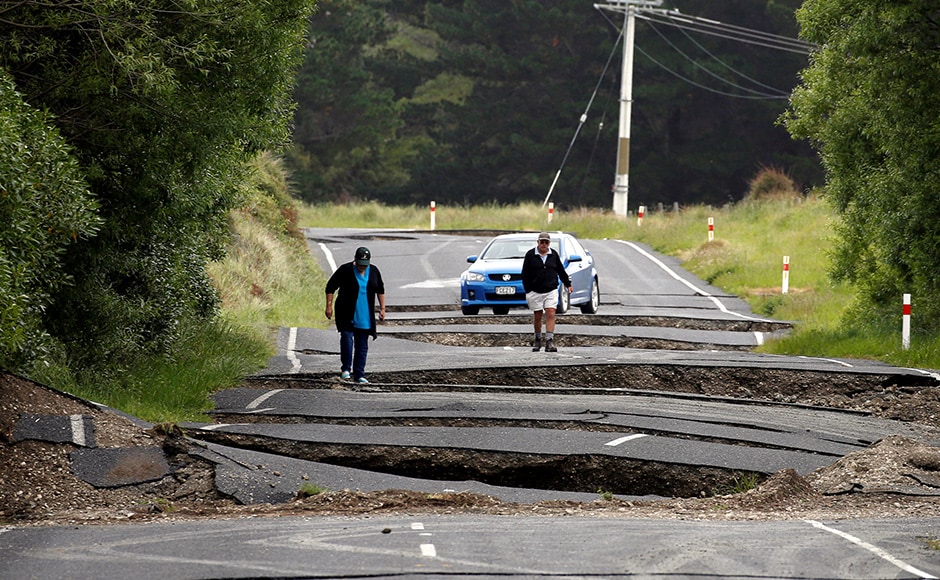 Local residents Chris and Viv Young look at damage caused by an earthquake along State Highway One near the town of Ward, south of Blenheim on New Zealand's South Island, November 14, 2016. REUTERS