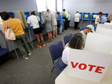 People cast their ballots for the US election at a crowded polling station as early voting begins in North Carolina. Reuters