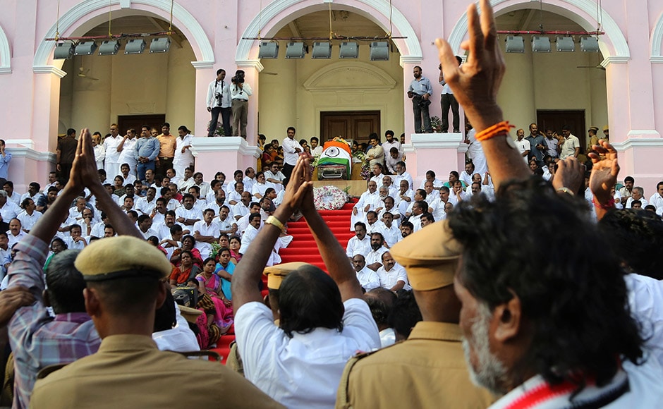 Supporters of India's Tamil Nadu state former Chief Minister Jayaram Jayalalithaa pay their respects to her body, wrapped in the national flag and kept for public viewing outside an auditorium in Chennai, India, Tuesday, Dec. 6, 2016. Jayalalithaa, the hugely popular south Indian actress who later turned to politics and became the highest elected official in the state of Tamil Nadu, died Monday. She was 68. (AP Photo/Aijaz Rahi)
