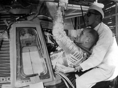 A file image of John Glenn (left) being helped into the Mercury capsule Friendship 7 during training for his Feburary 20, 1962, space flight. AFP