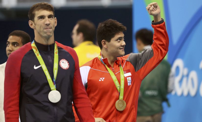 Joseph Schooling of Singapore celebrates his gold win next to Michael Phelps of USA. Reuters