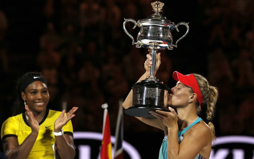 Germany's Angelique Kerber kisses the trophy as Serena Williams of the U.S. claps after the Australian Open final. Reuters