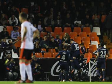 The Malaga players celebrate as a Valencia player looks dejected. Image credit: Twitter/@LaLiga