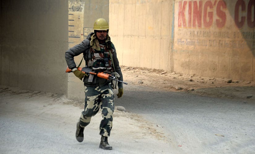 A member of the security force conducts a search during the encounter. Firstpost/Sameer Yasir
