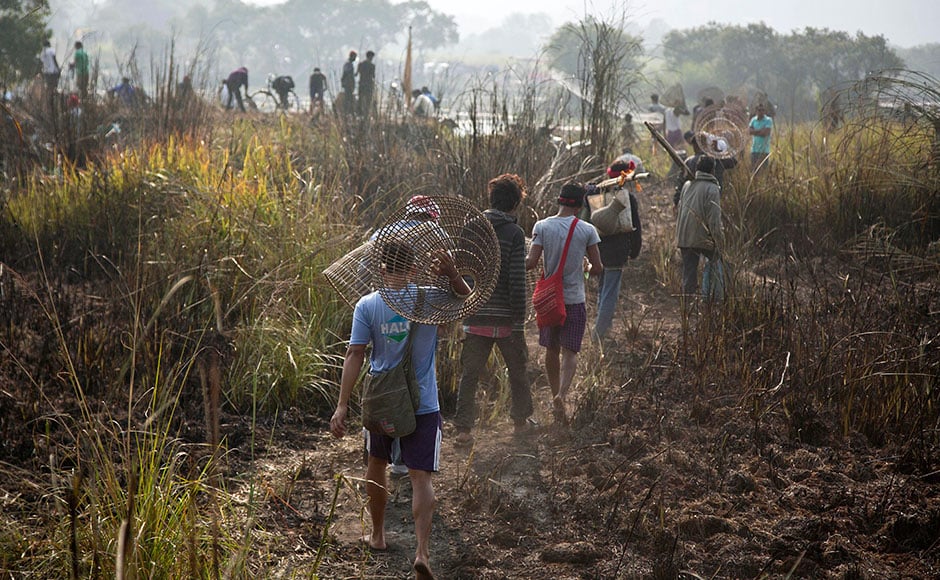 Tribal men walk with their fishing tools to participate in community fishing as part of Bhogali Bihu celebrations in Panbari village, some 50 km east of Guwahation13 January, 2017. Tribal men walk with their fishing tools to participate in community fishing as part of Bhogali Bihu celebrations in Panbari village, some 50 km east of Guwahation13 January, 2017.