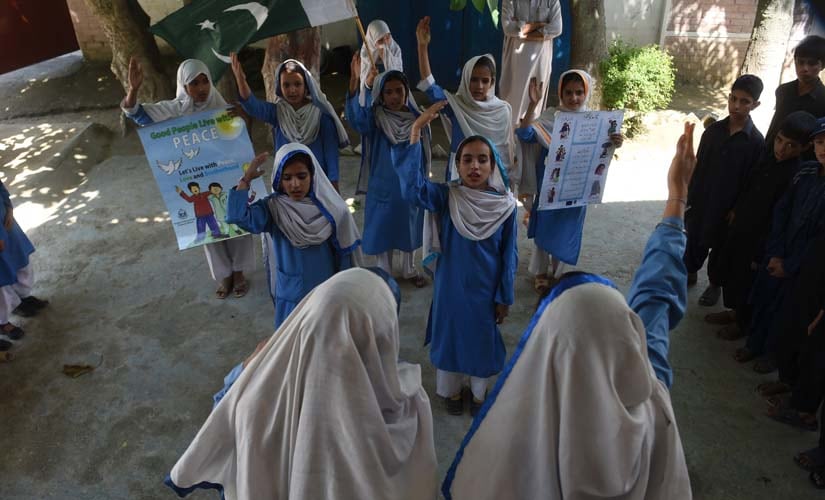 In this photograph taken on August 30, 2016, Hindko speaking schoolchildren sing the national anthem at their school in Mansehra. Around a hundred women have gathered in a community centre in Peshawar, the heart of Pakistan's fabled northwest — but they are conversing in a dialect incomprehensible to the Pashtun ethnic group that dominates the region. AFP