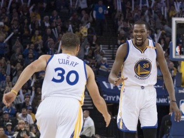 Golden State Warriors Kevin Durant celebrates with Stephen Curry during the third quarter against the Cleveland Cavaliers. Reuters