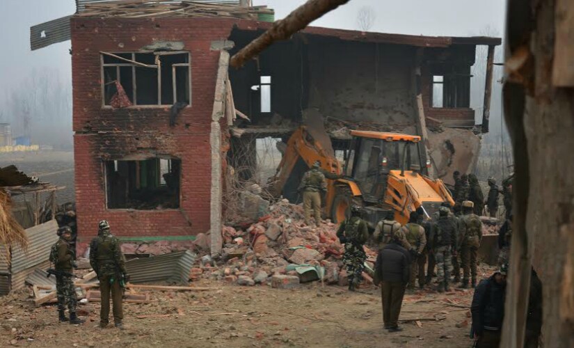 Security forces try to recover the bodies of slain militants who were killed in a 48-hour long fierce gun battle in South Kashmir’s Arwani Village. Firstpost/Suhail Bhat