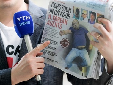 A reporter holds up a local newspaper during his report in front of the morgue at Kuala Lumpur General Hospital where Kim Jong Nam's body is held for autopsy in Malaysia . Reuters