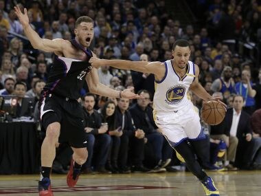 Golden State Warriors' Stephen Curry, right, drives past Los Angeles Clippers' Blake Griffin. AP