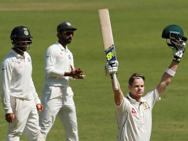 Australian captain Steve Smith (R) celebrates his century as the Indian players look on in the first Test in Pune. Reuters