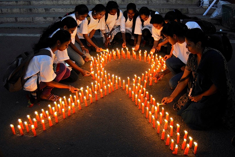 Staff members of a government-run pharmaceutical college light candles arranged in the formation of a ribbon to promote cancer awareness and mark World Cancer Day, in the southern Indian city of Bengaluru, formerly known as Bangalore, February 4, 2015. REUTERS/Abhishek N. Chinnappa (INDIA - Tags: HEALTH SOCIETY ANNIVERSARY) - RTR4O7YR