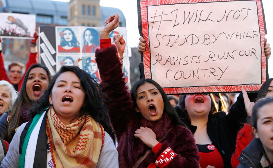 Inmate Ahmed, center, and other women chant along during a rally at Washington Square Park, part of International Women's Day Strike NYC, Wednesday, March 8, 2017, in New York. The group is a coalition of dozens of grassroots groups and labor organizations. (AP Photo/Kathy Willens)
