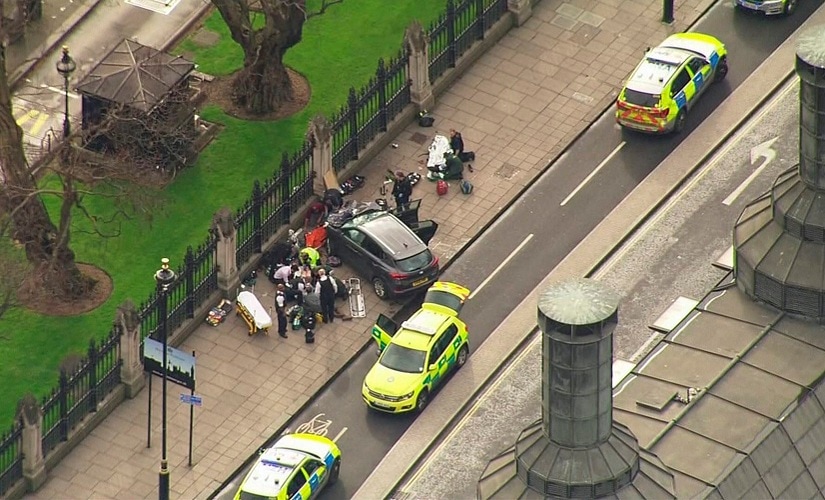 In this image taken from video police officers gather around a car adjacent to the Houses of Parliament on Wednesday. AP