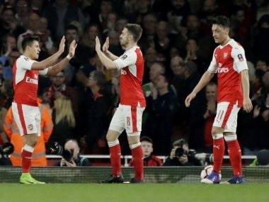 Arsenal's Aaron Ramsey, centre, is congratulated by Alexis Sanchez after scoring against Lincoln City. AP