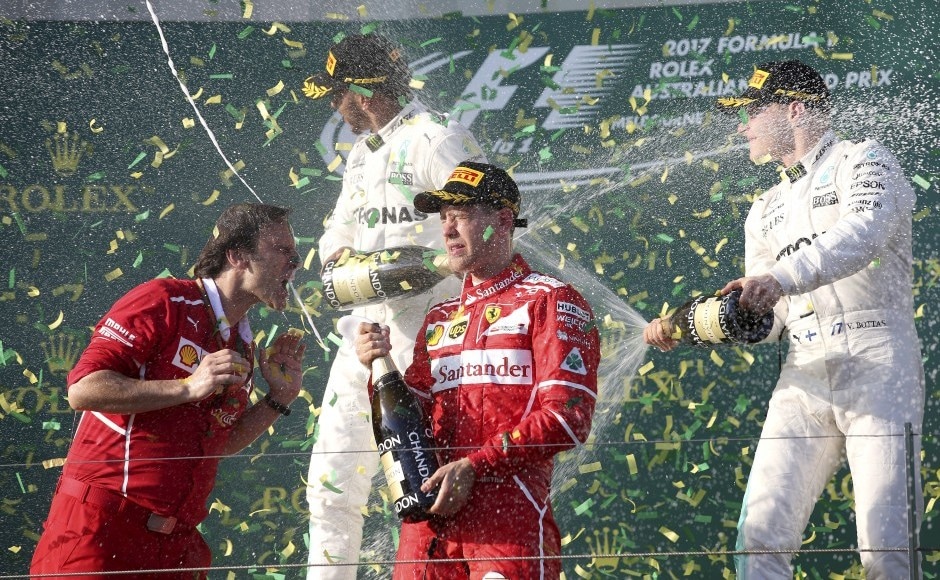 Ferrari team principal Maurizio Arrivabene, left, celebrates along with his driver Sebastian Vettel of Germany as Mercedes driver Lewis Hamilton of Britain, second from left, sprays teammate Valtteri Bottas of Finland, right, after the Australian Formula One Grand Prix in Melbourne, Australia, Sunday, March 26, 2017. Vettel won the race ahead of Hamilton and Bottas. (AP Photo/Rick Rycroft)