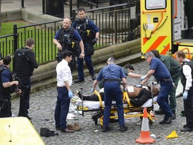 A man is treated by emergency services as police look on at the scene outside the Houses of Parliament London, Wednesday, March 22, 2017. London police say they are treating a gun and knife incident at Britain's Parliament "as a terrorist incident until we know otherwise." The Metropolitan Police says in a statement that the incident is ongoing. It is urging people to stay away from the area. Officials say a man with a knife attacked a police officer at Parliament and was shot by officers. Nearby, witnesses say a vehicle struck several people on the Westminster Bridge. AP