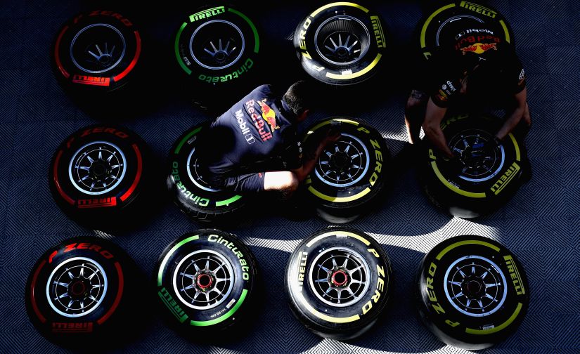 Red Bull Racing team members work on tyres in the Paddock during the Formula One winter testing. Getty