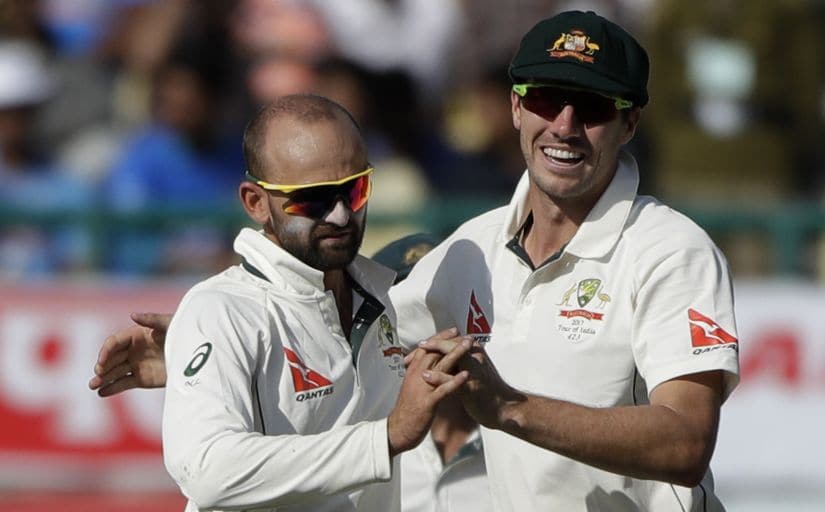 Australia's Nathan Lyon, left, and Pat Cummins celebrate the dismissal of India's Ravichandran Ashwin. AP