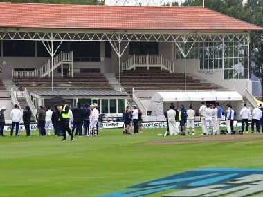New Zealand and South Africa players and officials stand in the middle of the field after a fire alarm on day three of the first Test. AFP