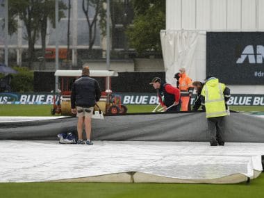 Ground staff clear water from the covers as rain delays play on the final day of the first Test between South Africa and New Zealand. AP