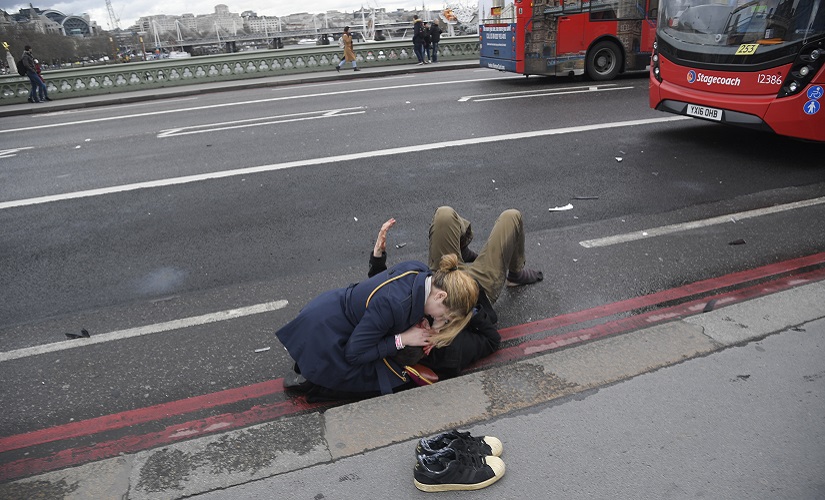 A woman assists an injured person after an incident on Westminster Bridge in London, March 22, 2017. REUTERS/Toby Melville - RTX326E2