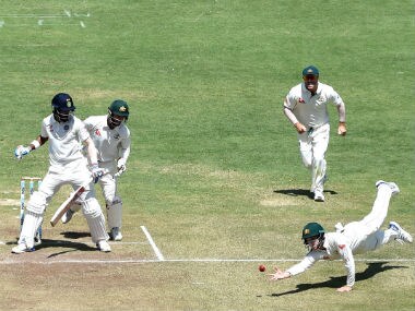 Australian players look on as Peter Handscomb (R) dives to attempt a catch off India's KL Rahul on Day 3 of the Pune Test. AFP