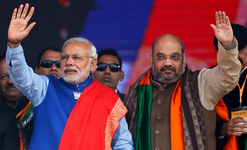 Indian Prime Minister Narendra Modi (L) and Amit Shah, the president of India's ruling Bharatiya Janata Party (BJP), wave to their supporters during a campaign rally ahead of state assembly elections, at Ramlila ground in New Delhi January 10, 2015. REUTERS/Anindito Mukherjee (INDIA - Tags: POLITICS ELECTIONS) - RTR4KTIV