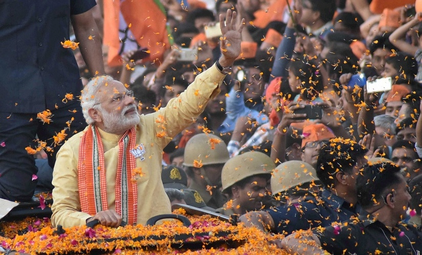 Prime Minister Narendra Modi waves to people during his road show in Varanasi on Sunday. PTI