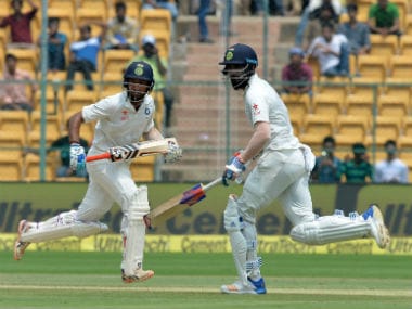 India's KL Rahul (R) and Cheteshwar Pujara run between the wickets in second Test against Australia in Bangalore. AFP